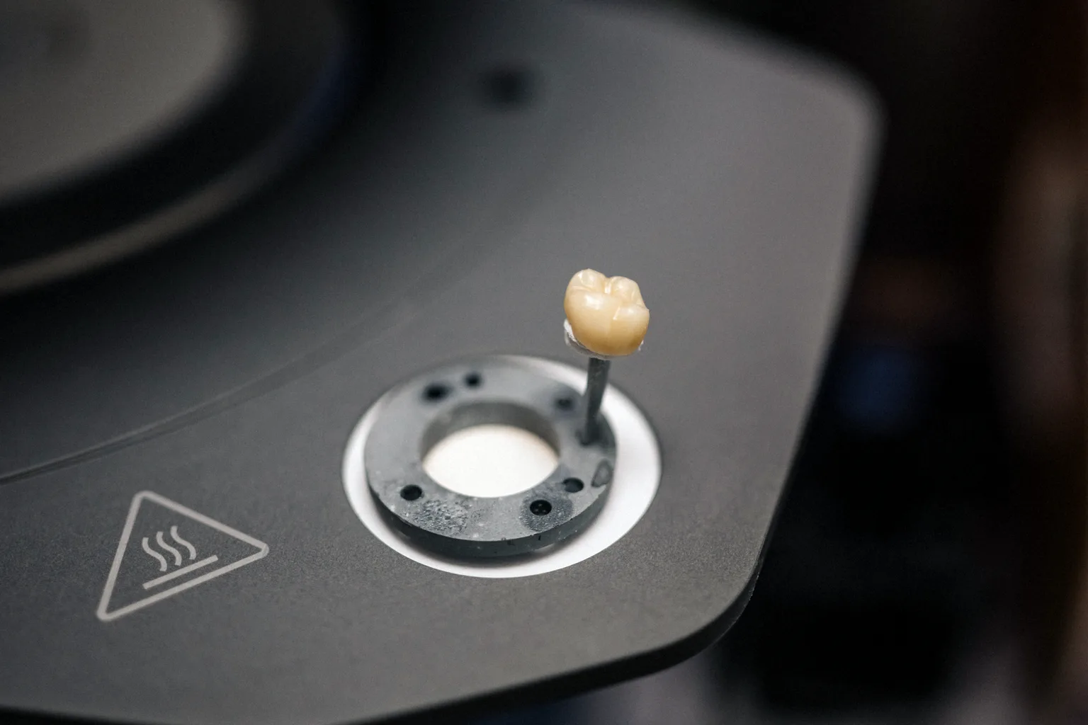 Crown on the firing tray of a ceramic furnace at Prime Lab Dental Studios